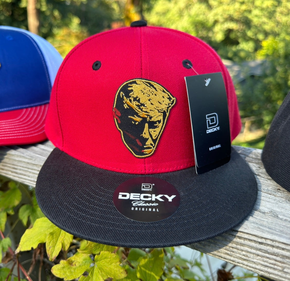 203. Trump Bloody Mugshot - embroidered metallic gold patch on Red/Black Decky 6 panel flat bill snapback